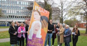 „Wir sagen Nein zu Gewalt gegen Frauen“: Mitglieder des Netzwerks gegen häusliche Gewalt im Landkreis Harburg hissen erste Fahne vor dem Winsener Kreishaus. Foto: Landkreis Harburg