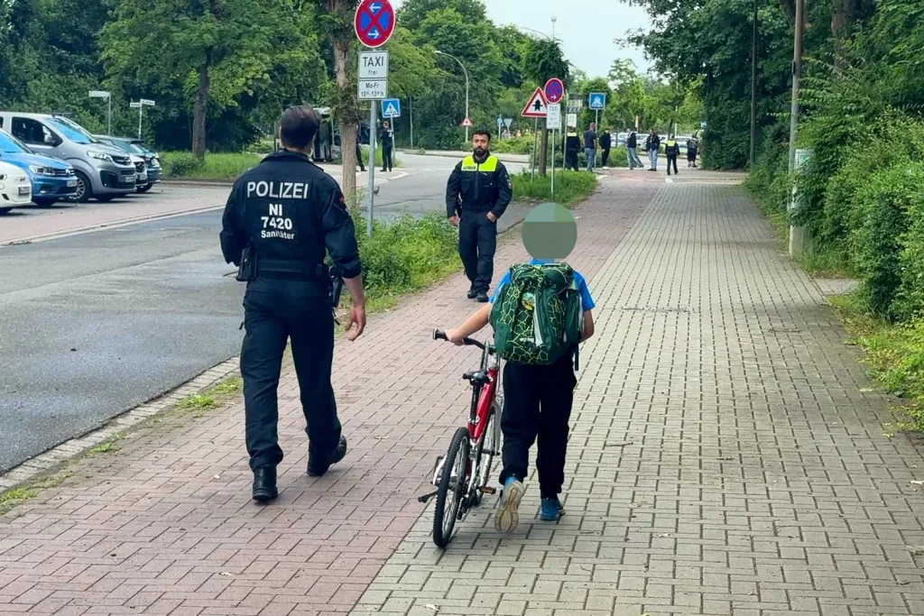 Ein Polizist begleitet eine Schüler vom Schulgelände. Foto: Hamann