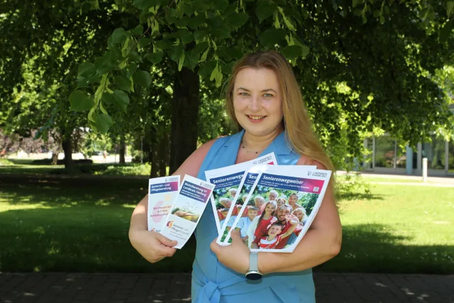 Isabella Kruppa präsentiert den neuen Seniorenwegweiser sowie die weiteren Infobroschüren zur Ehrenamtlichen Wohnberatung und zum Senioren- und PflegeStützpunkt. Foto: Landkreis Harburg