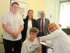 Dörthe Erdmann impft den 14-jährige Maximilian unter den Blicken seines Bruders Bastian, Kreisrätin Ana Cristina Bröcking und Landrat Rainer Rempe. Foto: Landkreis Harburg